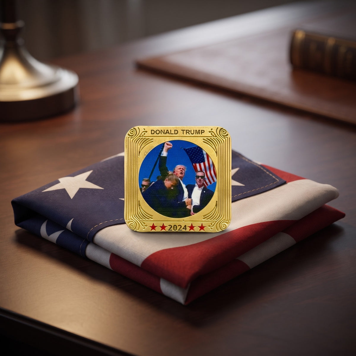Trump July 13 Square Coin resting on a folded flag on a desk