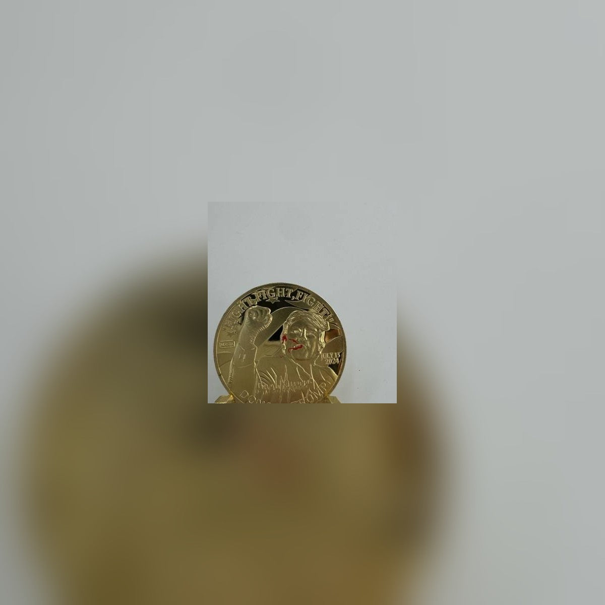 Trump Fight Fight Fight Coin on a small gold stand