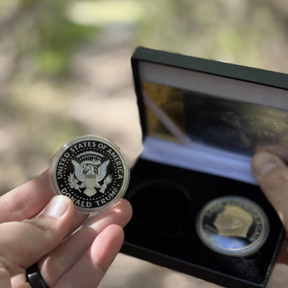 Silver-plated Trump coin held to show the eagle reverse, case in the background