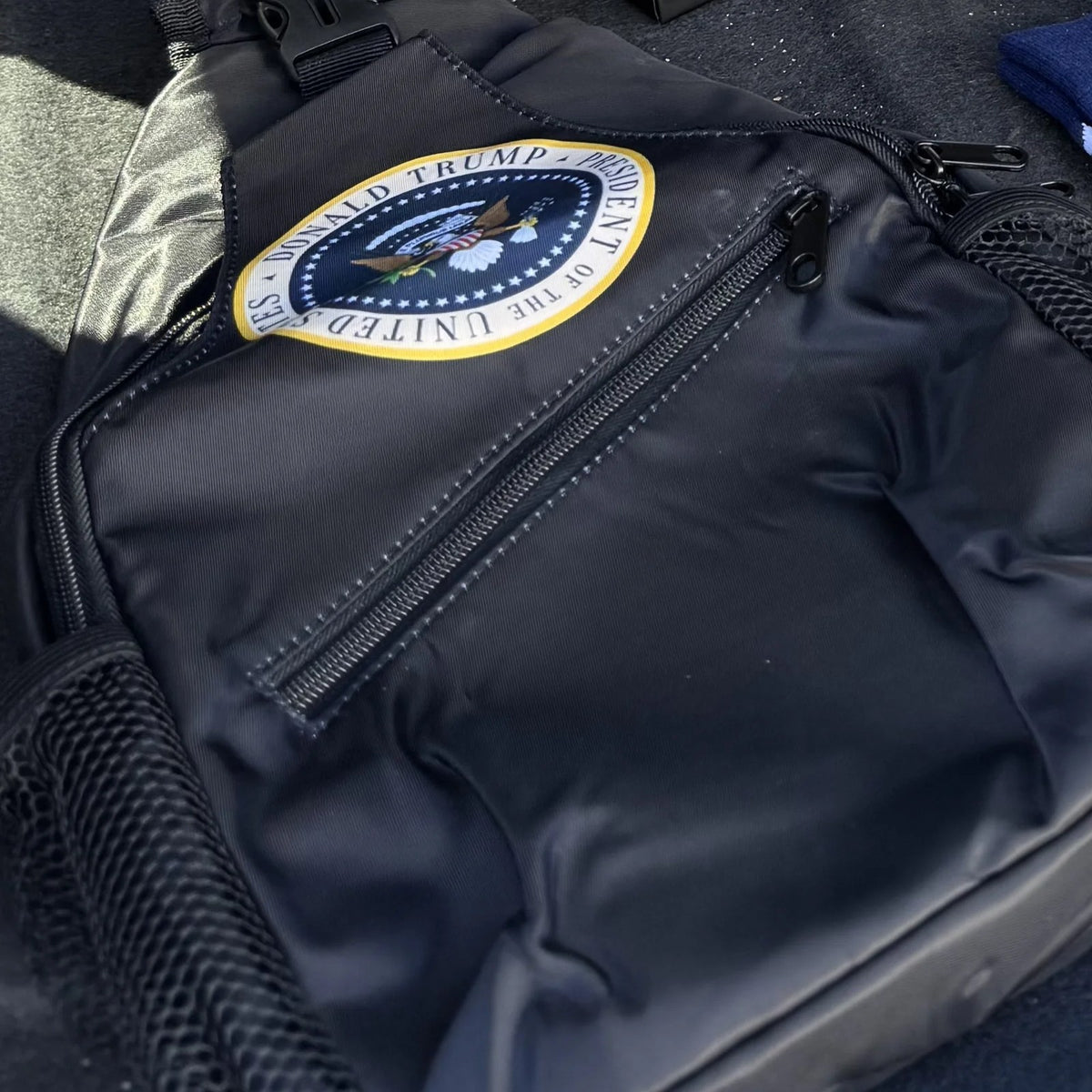 Trump Seal Sling Bag in the back of a car
