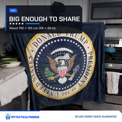 Man holding up the Trump Presidential Blanket in a kitchen to show its full size