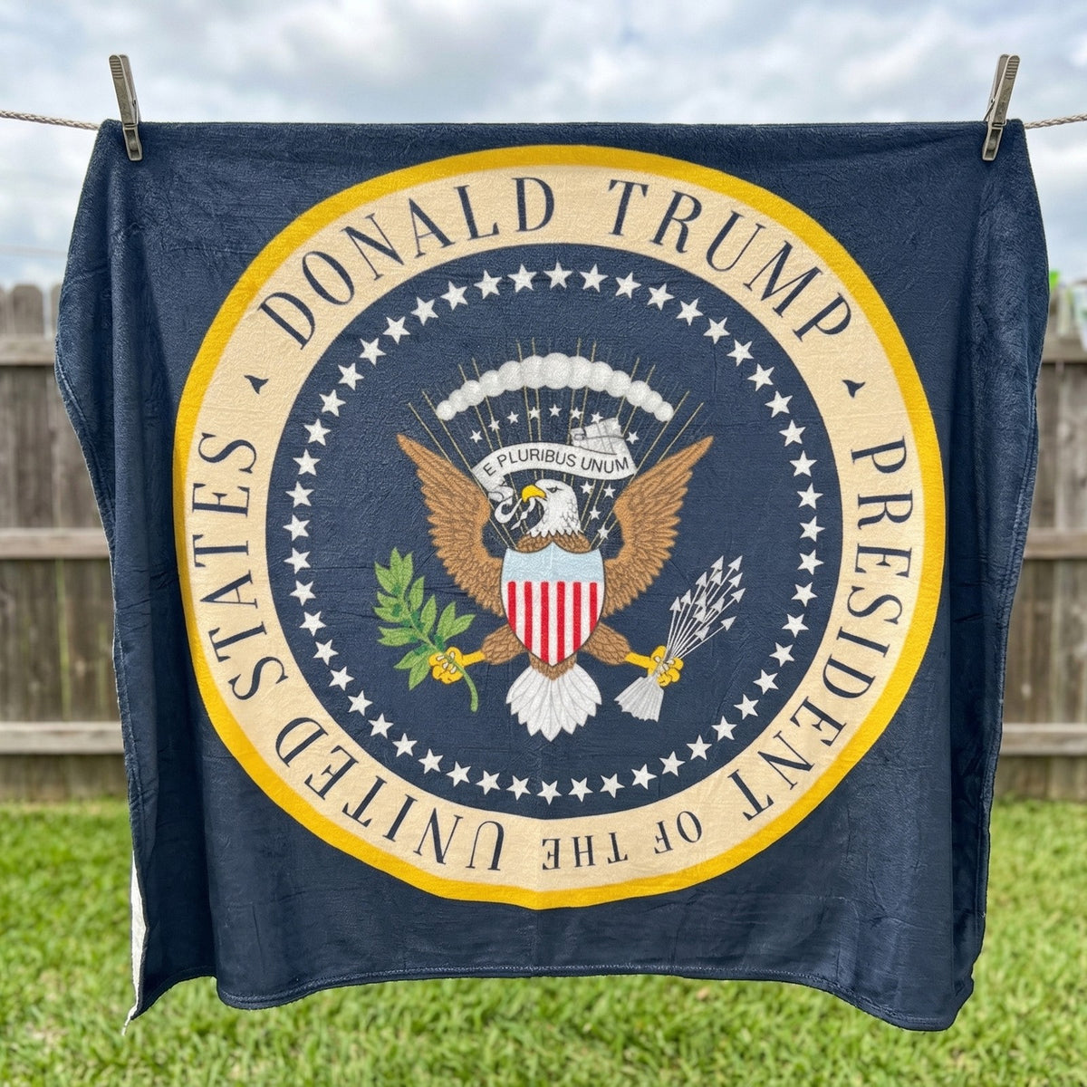 Trump Presidential Blanket hanging on a clothesline, straight-on view of the full seal-style design