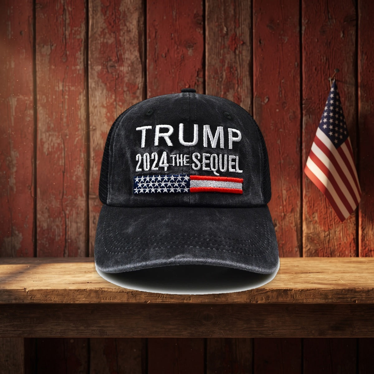 Trump 2024 The Sequel Hat on a rustic barn shelf with a small flag