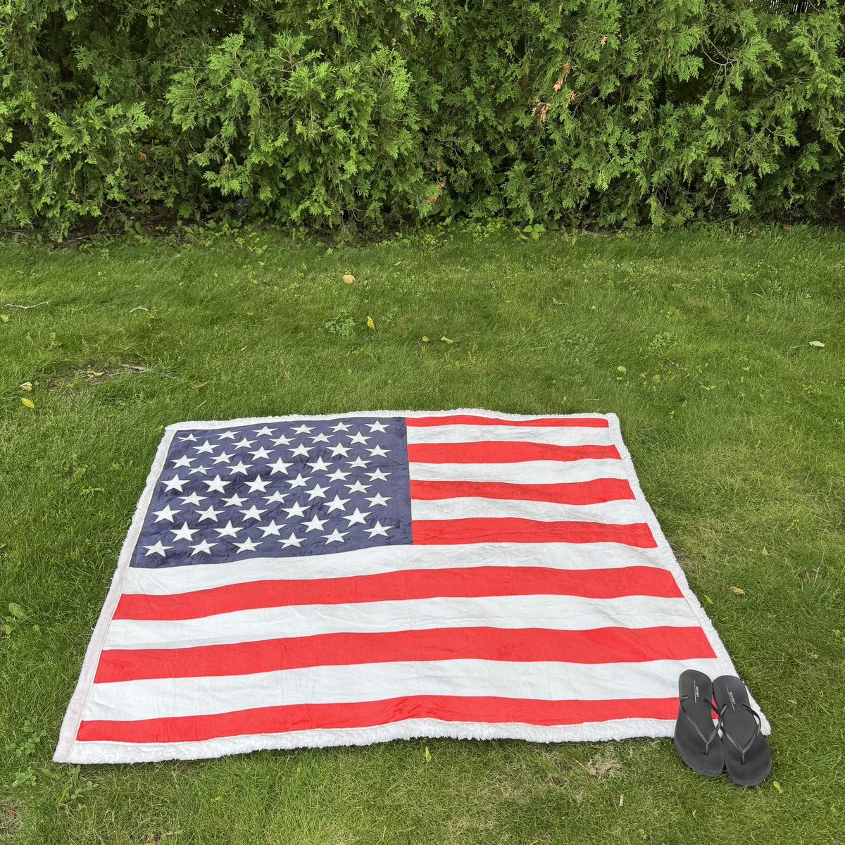 USA Flag Throw Blanket spread flat on the lawn, seen from above