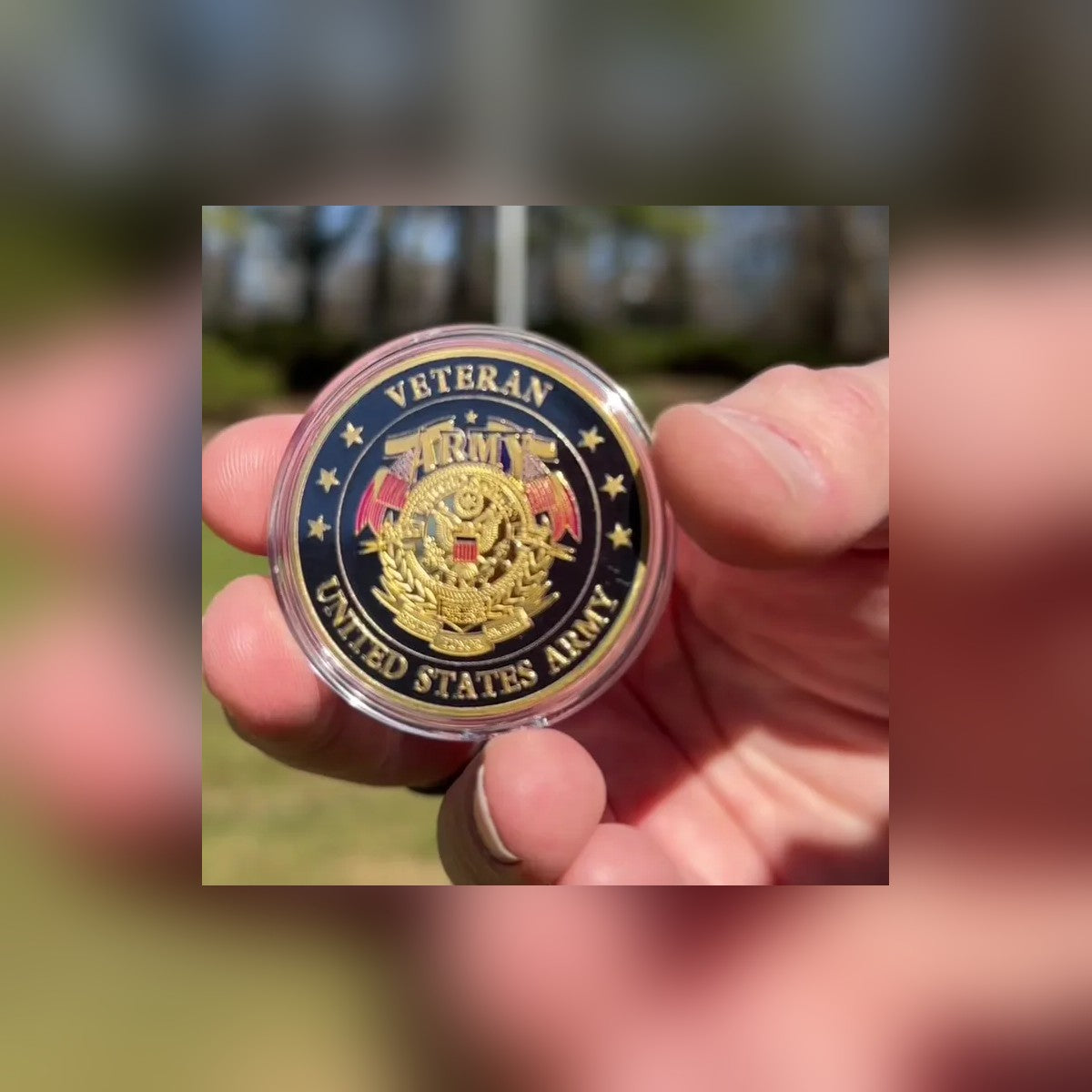 Army Veteran Tribute Coin in its clear capsule, held outdoors