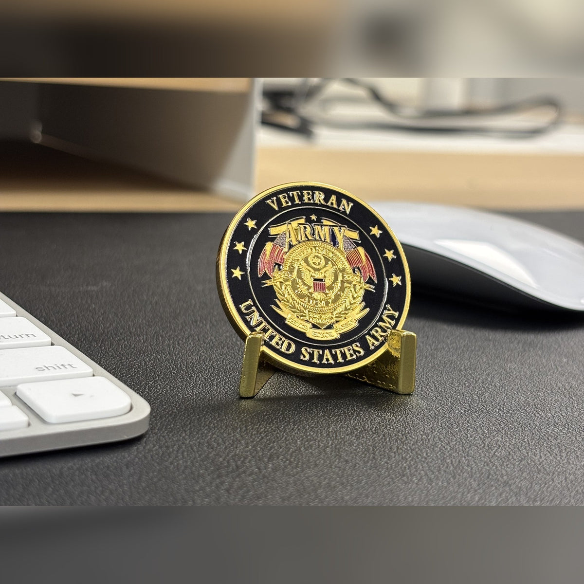 Army Veteran Tribute Coin on a small stand on a desk beside a keyboard