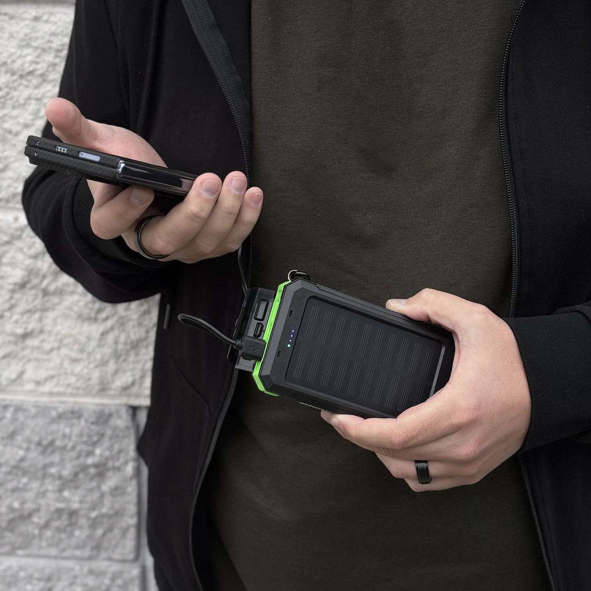 Man charging his phone from the Waterproof Solar Charger