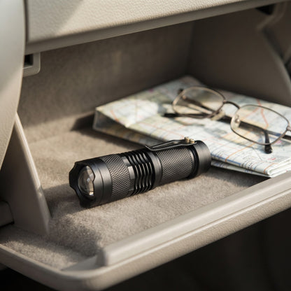 Zoom Torch Flashlight in a car glovebox beside reading glasses and a map